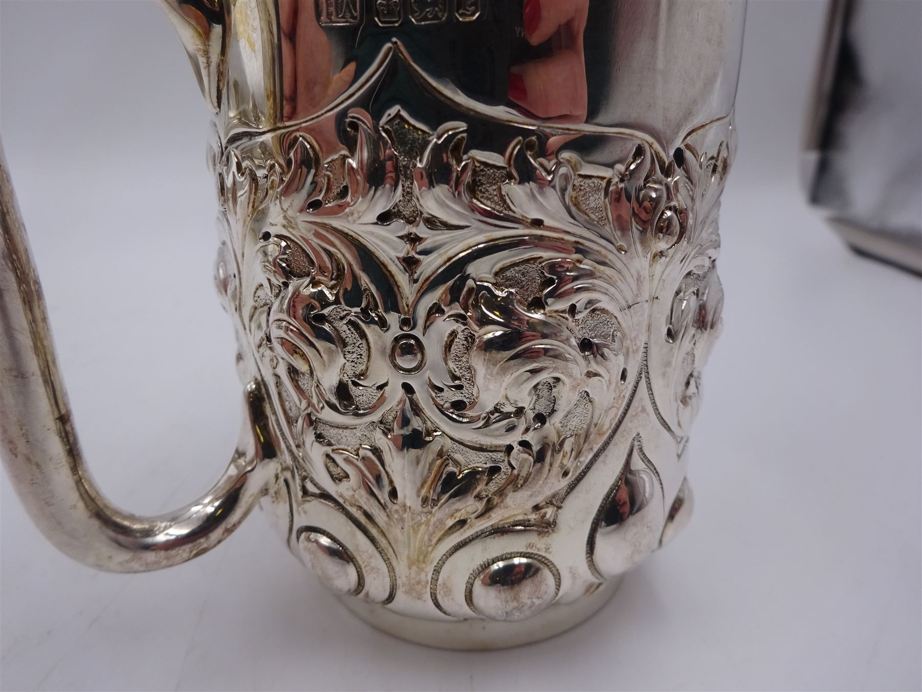 Late Victorian silver christening mug, with C handle and gilt interior, the body profusely embossed with floral and foliate decoration, hallmarked Atkin Brothers, Sheffield 1897, H10cm