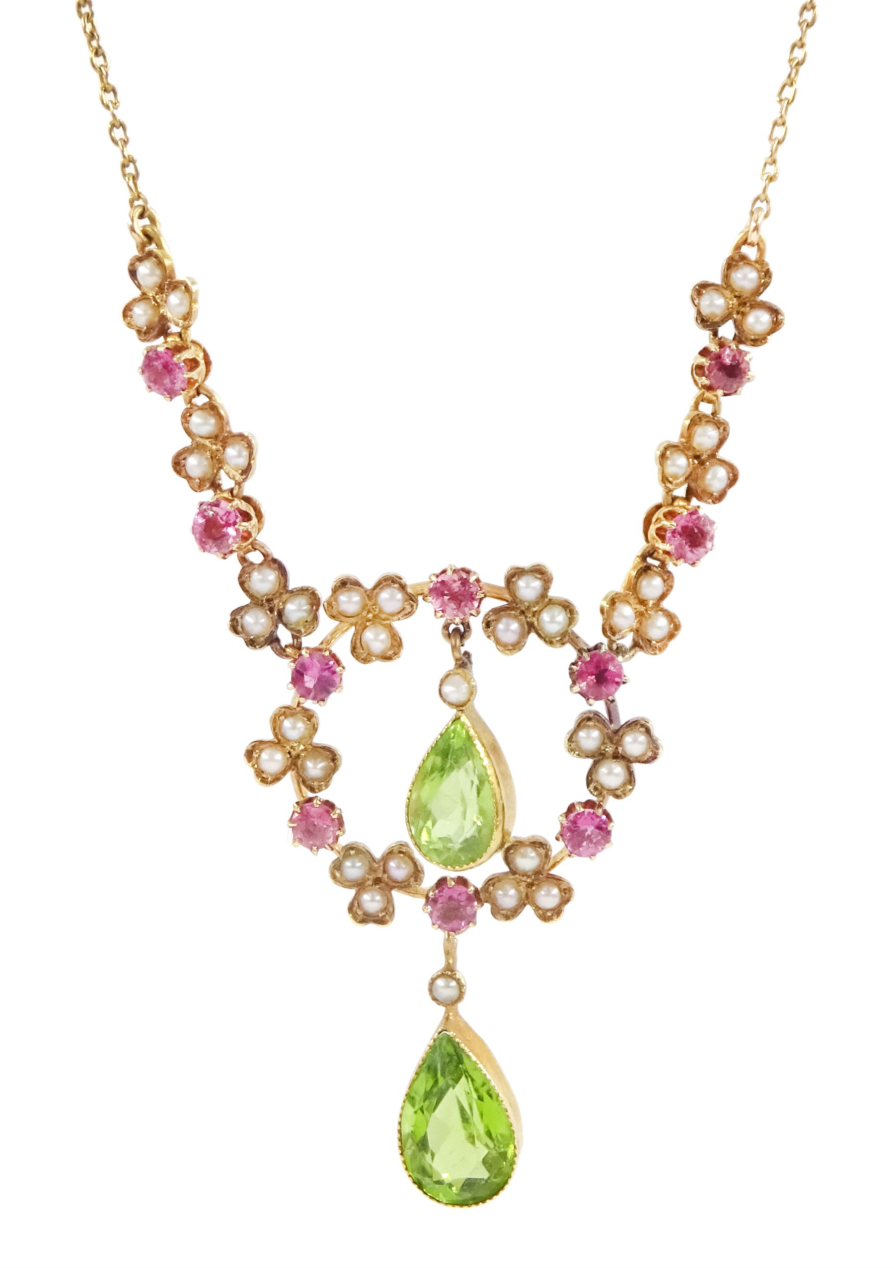 Early 20th century 15ct gold peridot, pink tourmaline and seed pearl necklace, two pear cut peridot drops, suspending from circular floral deign pendant, set with round cut tourmalines and seed pearls, to three further floral clusters and two tourmalines set either side, on trace link chain necklace, stamped 15c