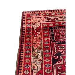 Persian Hamadan indigo and crimson ground rug, the field filled with three shaped medallions, overall geometric design, decorated with sandikli and hac motifs, geometric main border with repeating hooked motifs, within guard stripes decorated with small flower heads, outer crenelated fence band 