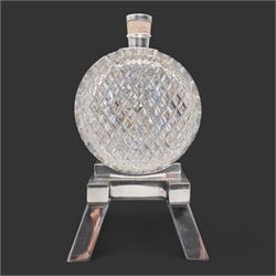 Late 19th/ early 20th century cut glass and silver plate whisky decanter by John Grinsell & Sons, of barrel form, with cork stopper and silver plate strapwork mounts, the tap suspending a bucket form measure, on trestle form support, H24cm x L24cm 