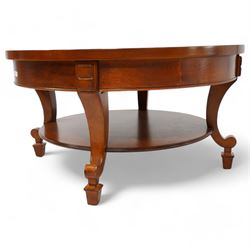 French cherry wood circular coffee table, segment veneered top with crossbanding over plain frieze, curved supports united by magazine under-tier, on spade feet