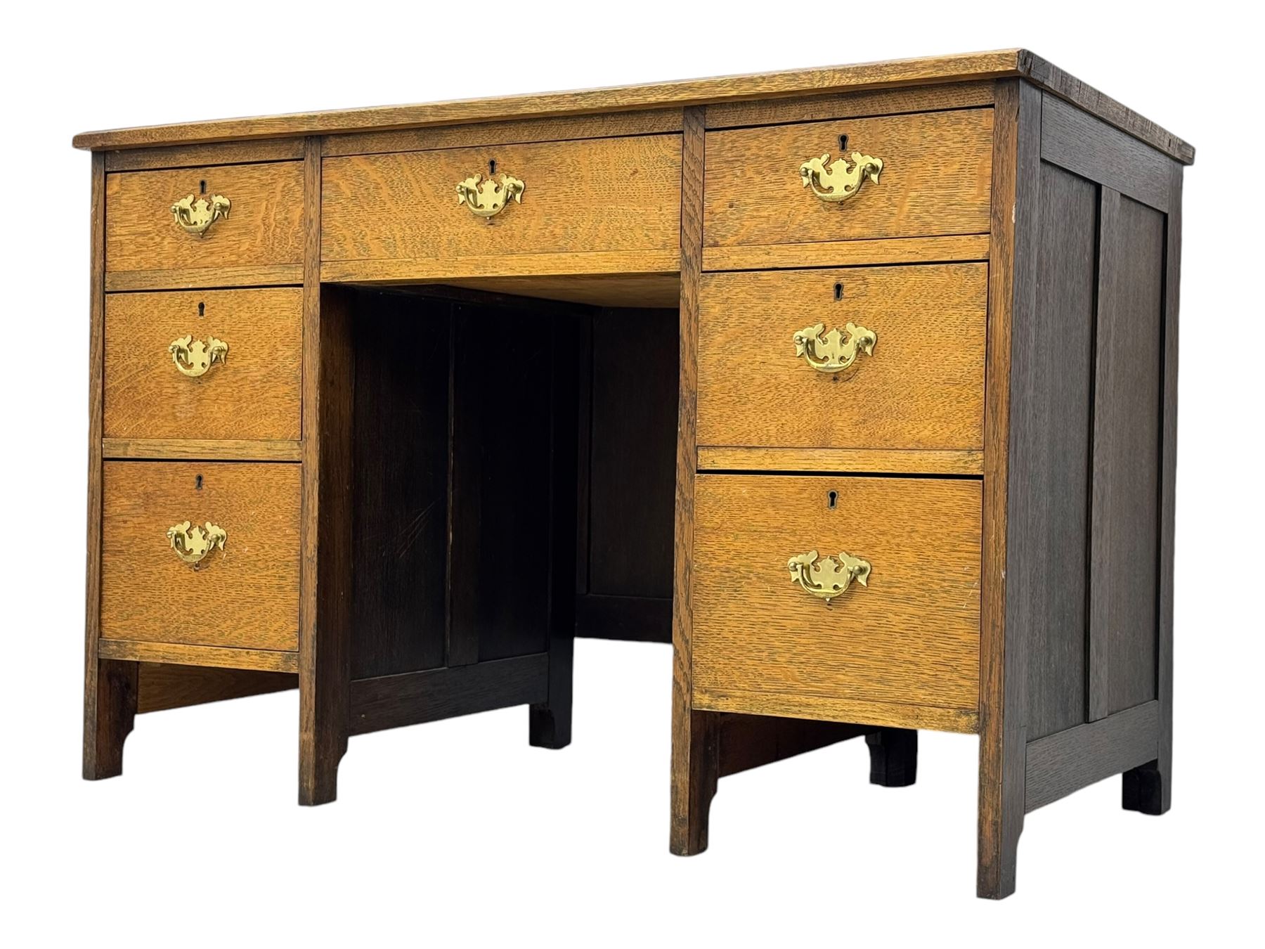 Edwardian oak twin pedestal desk, moulded rectangular top with inset writing surface, fitted with seven drawers, panelled sides, on stile supports 