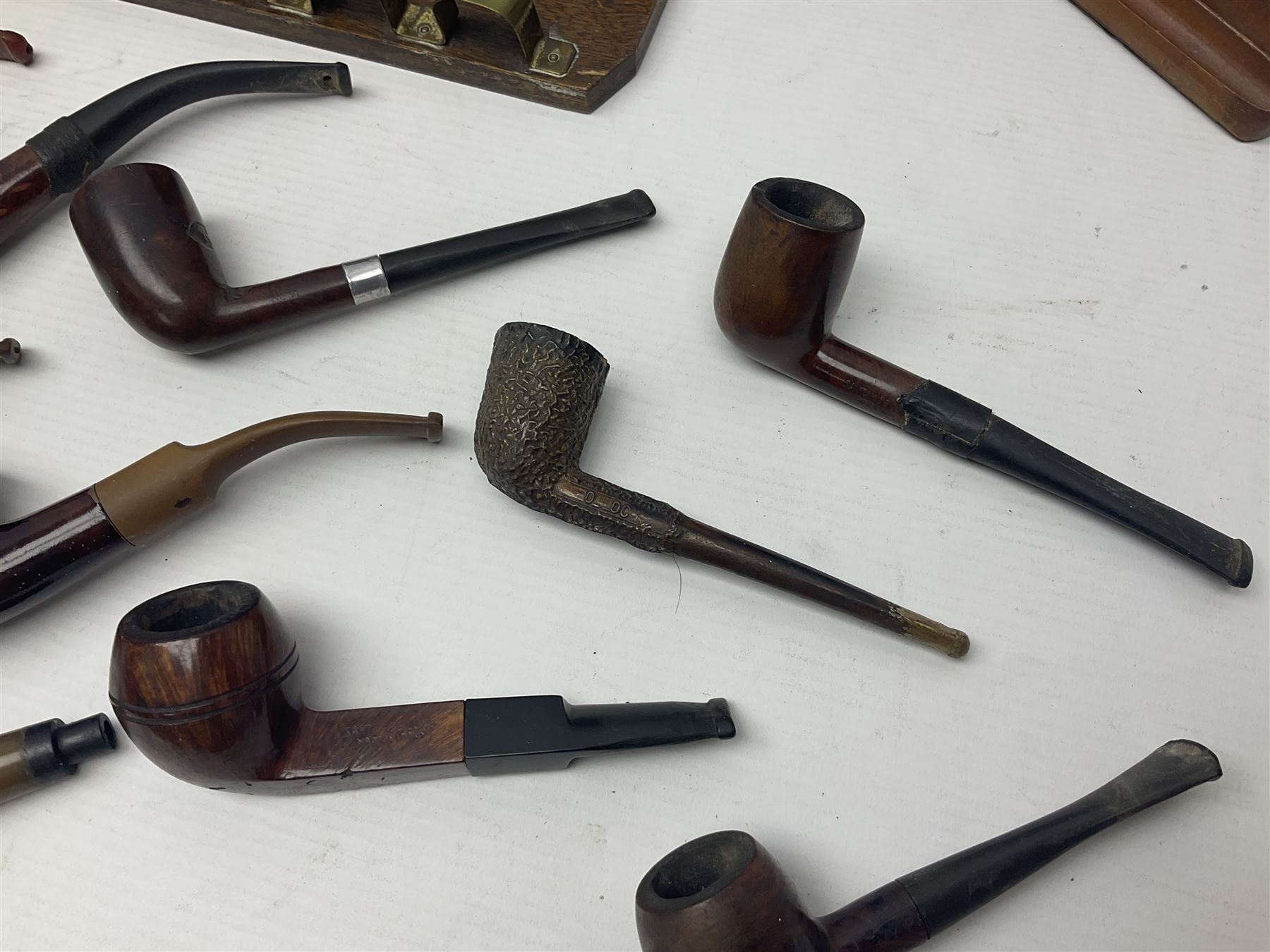 Collection of smoking pipes including Meerschaum pipe, carved as a female head, Briars and clay examples, etc and four pipe racks/stands