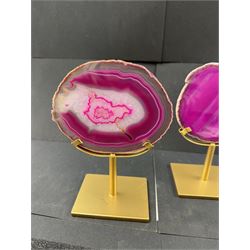 Pair of pink agate slices, polished with rough edges, raised upon gilt metal stands, H20cm