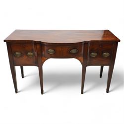 George III mahogany break bow-front sideboard, fitted with three drawers, the corner brackets inlaid with quarter shell motifs, pressed brass oval handle plates decorated with oak leaves and acorns, on square tapering supports