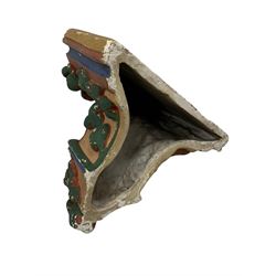 Two Victorian polychromed plaster cast corbels or wall brackets, canted rectangular tops over moulded edge and curled fruiting foliage