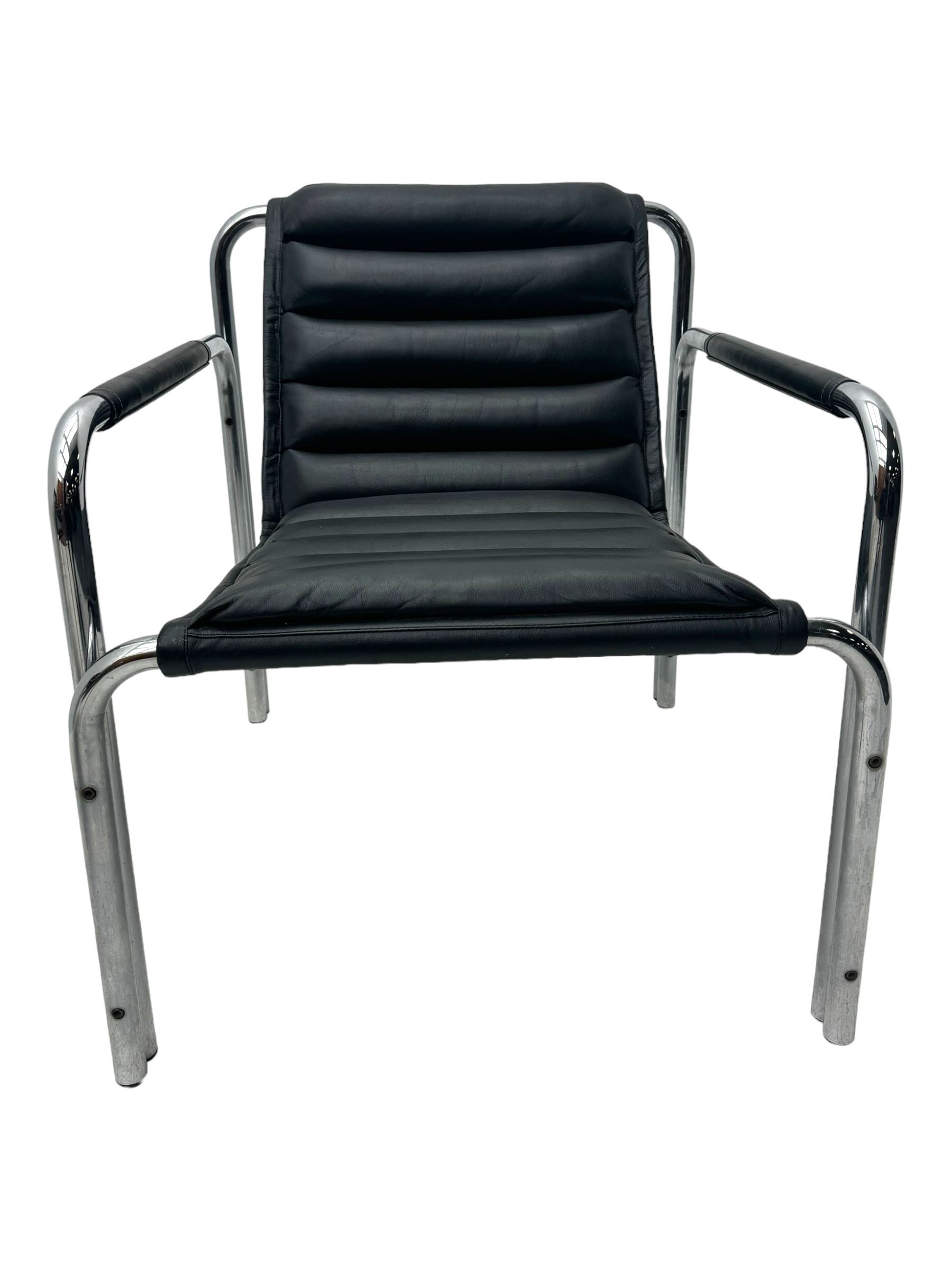 Baroumand Designs - pair of mid 20th century modernist armchairs, slung black leather seat with horizontal channel tufting, tubular chrome frame with curved arms, raised on tubular supports