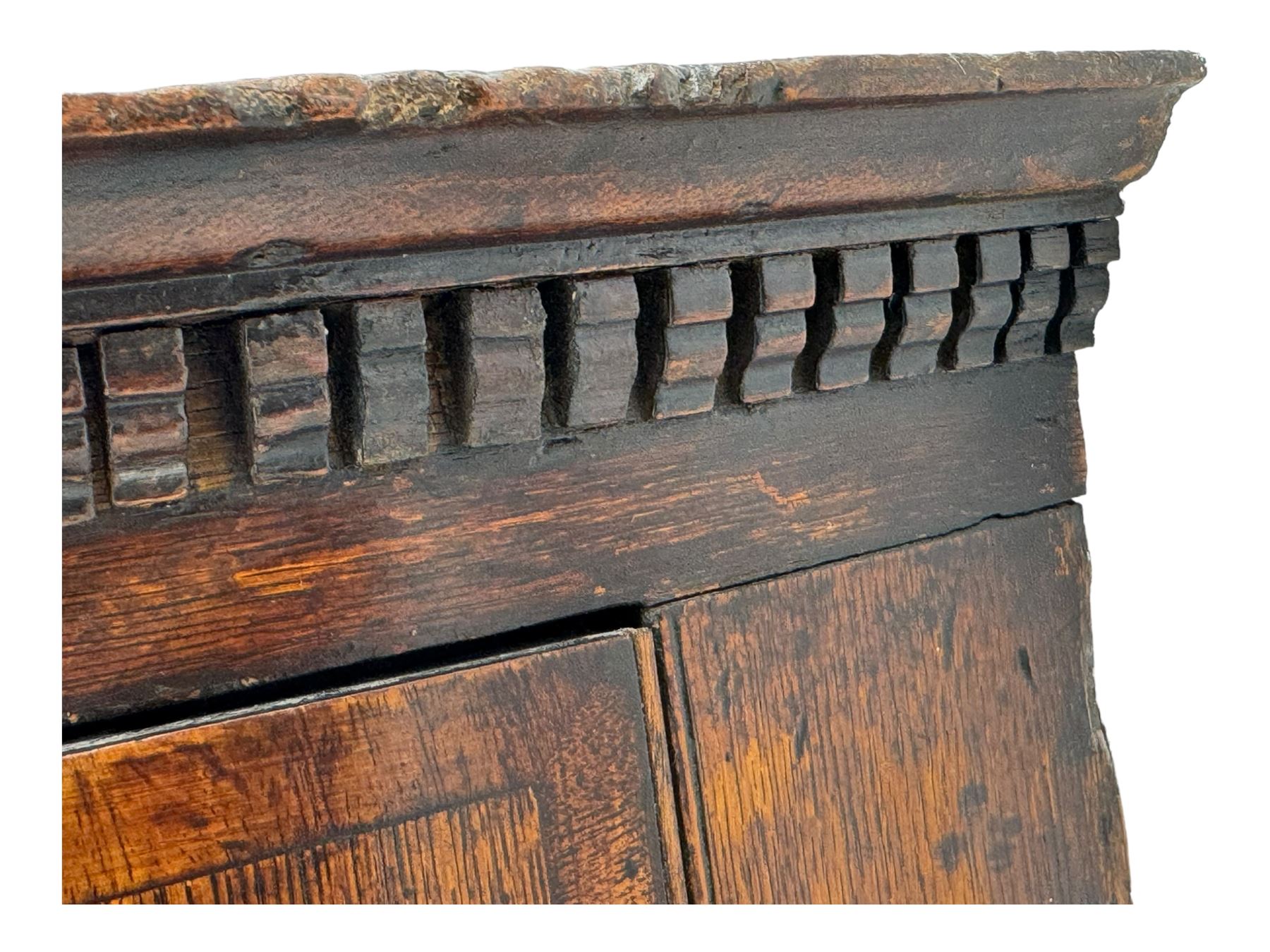 Georgian oak corner cabinet, projecting cornice with shaped dentil frieze, over two panelled doors enclosing three shelves, on a plain plinth base