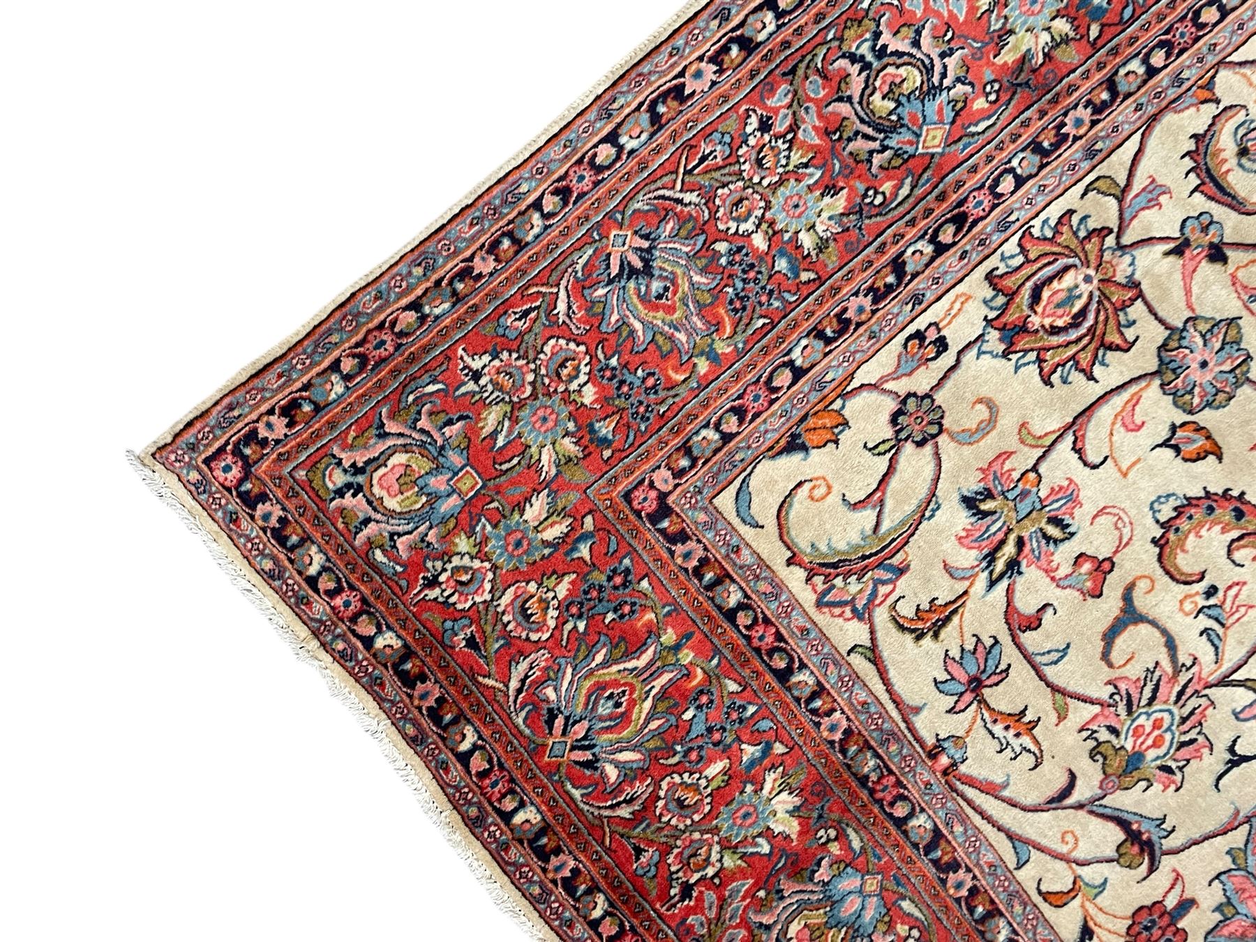 Persian Sarough ivory ground rug, the field decorated with curled leafy branches and palmettes, crimson ground border decorated with further palmettes and floral sprays, within guard stripes 