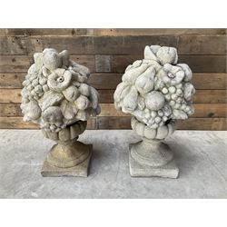 Pair of cast stone garden wall or gate finials depicting Fruit Piers, raised on separate circular squat column with plinth base