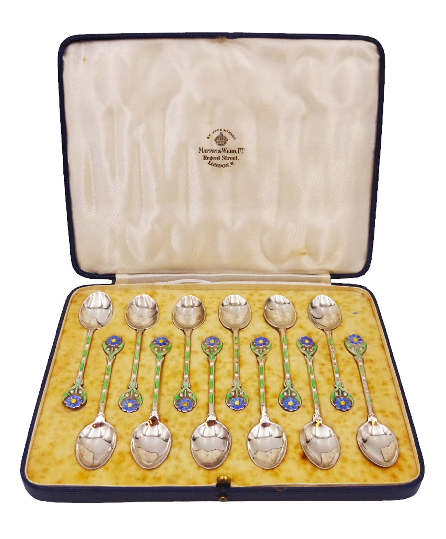 Set of twelve silver coffee spoons, each with enamelled blue flower to terminal and green and white enamel decoration to stem, hallmarked Mappin & Webb Ltd, Birmingham 1934, contained within fitted case