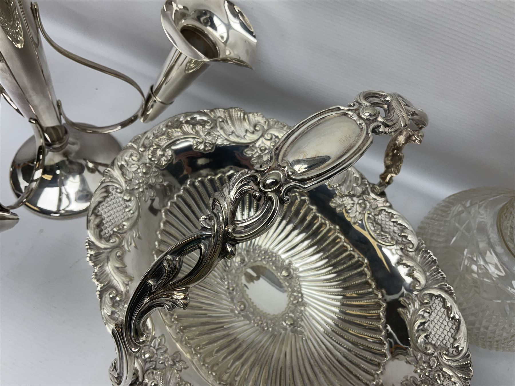 Silver plated three branch epergne, together with a silver plated cut glass claret jug, and silver plated embossed swing handled basket, epergne H30.5cm