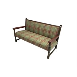 Late 19th century oak framed hall bench, back and seat upholstered in green and red tartan fabric with studwork leather border, arms upholstered in maroon leather, raised on turned supports united by stretcher