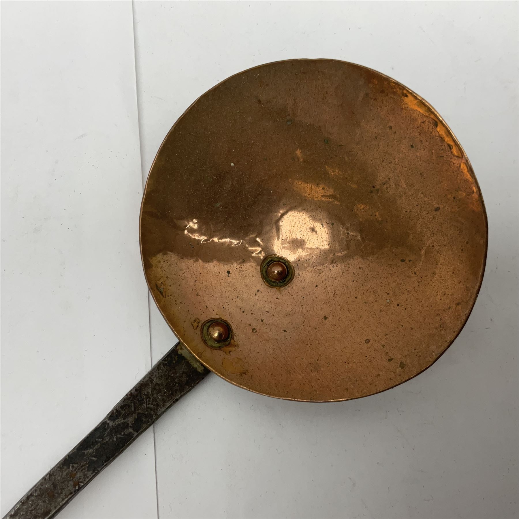 Large 19th century copper slotted spoon, with pierced flat bowl, L55cm, together with two 19th century iron handled ladles with circular copper bowls, largest example L48.5cm, (3)