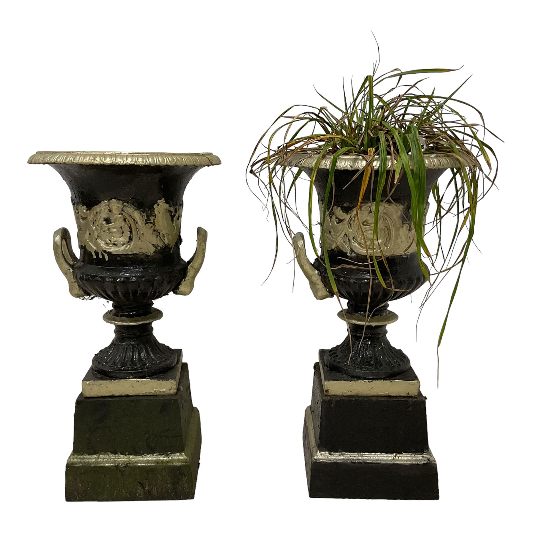 Pair of 20th century cast iron Campana-shaped urns on plinths, in ebonised and parcel-gilt painted finish