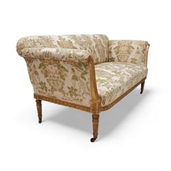 19th century gilt wood and gesso settee, upholstered in repeating floral pattern fabric, rolled arms decorated with trailing bead moulding and acanthus leaf, the seat rail with flower head band, on twist turned and foliate carved feet with brass castors 