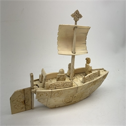 A Japanese carved ivory model of a sailing boat, surmounted by three carved figures (a/f), L22.5cm, together with a smaller sail boat with malachite hull and ivory sails and rudder, H18cm. 