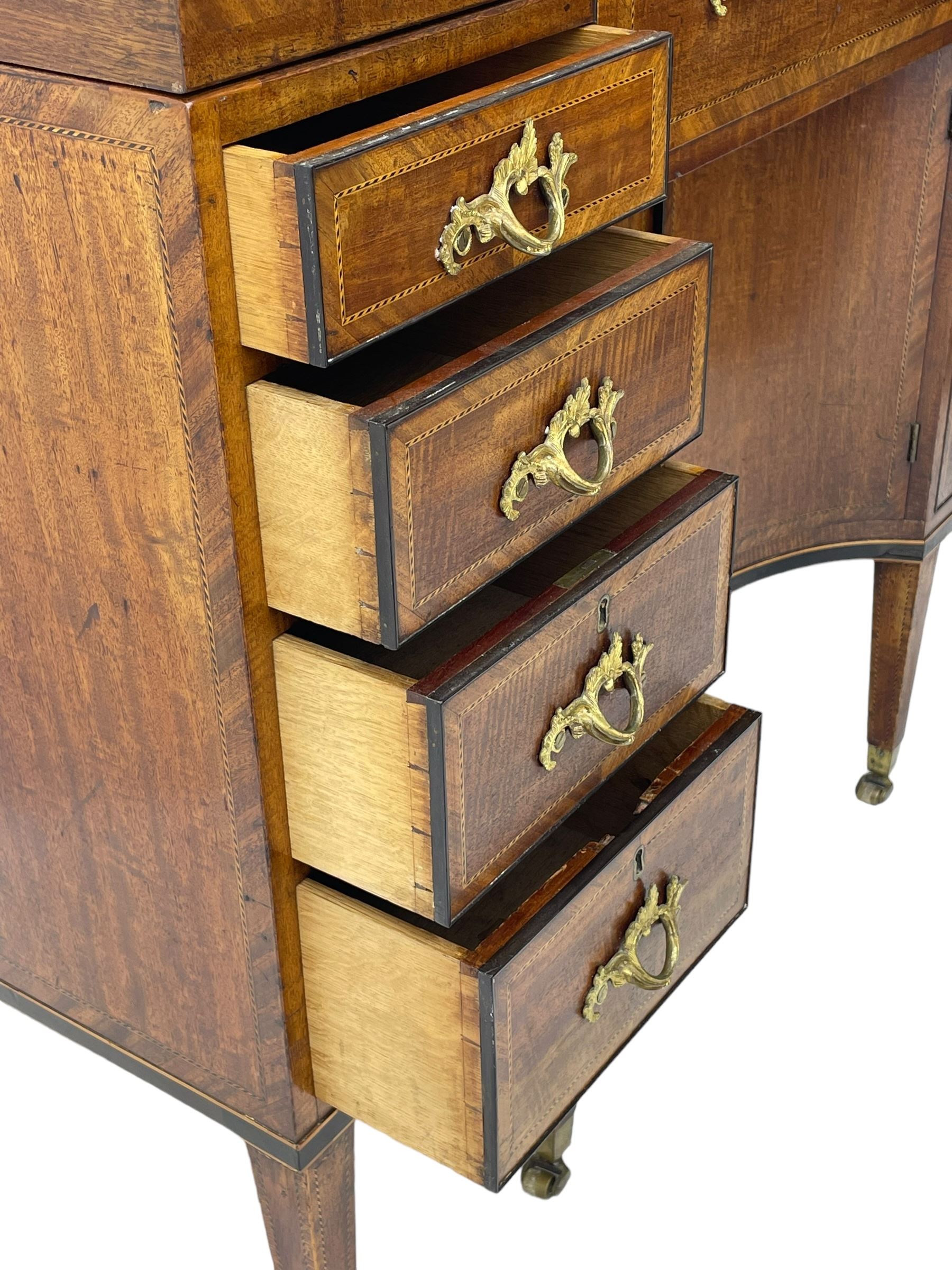 Late 19th century mahogany and satinwood dressing chest, the raised middle section hinges to reveal an interior fitted with lidded compartments, removable tray, single drawer and glass scent bottles, lift-up bevelled mirror with adjustable hinged mechanism, fitted with a further eight cock-beaded graduating drawers and curved kneehole with double cupboard, square tapering supports on brass cups and castors, inlaid throughout with checkered stringing, ornate Rococo cast gilt metal handles