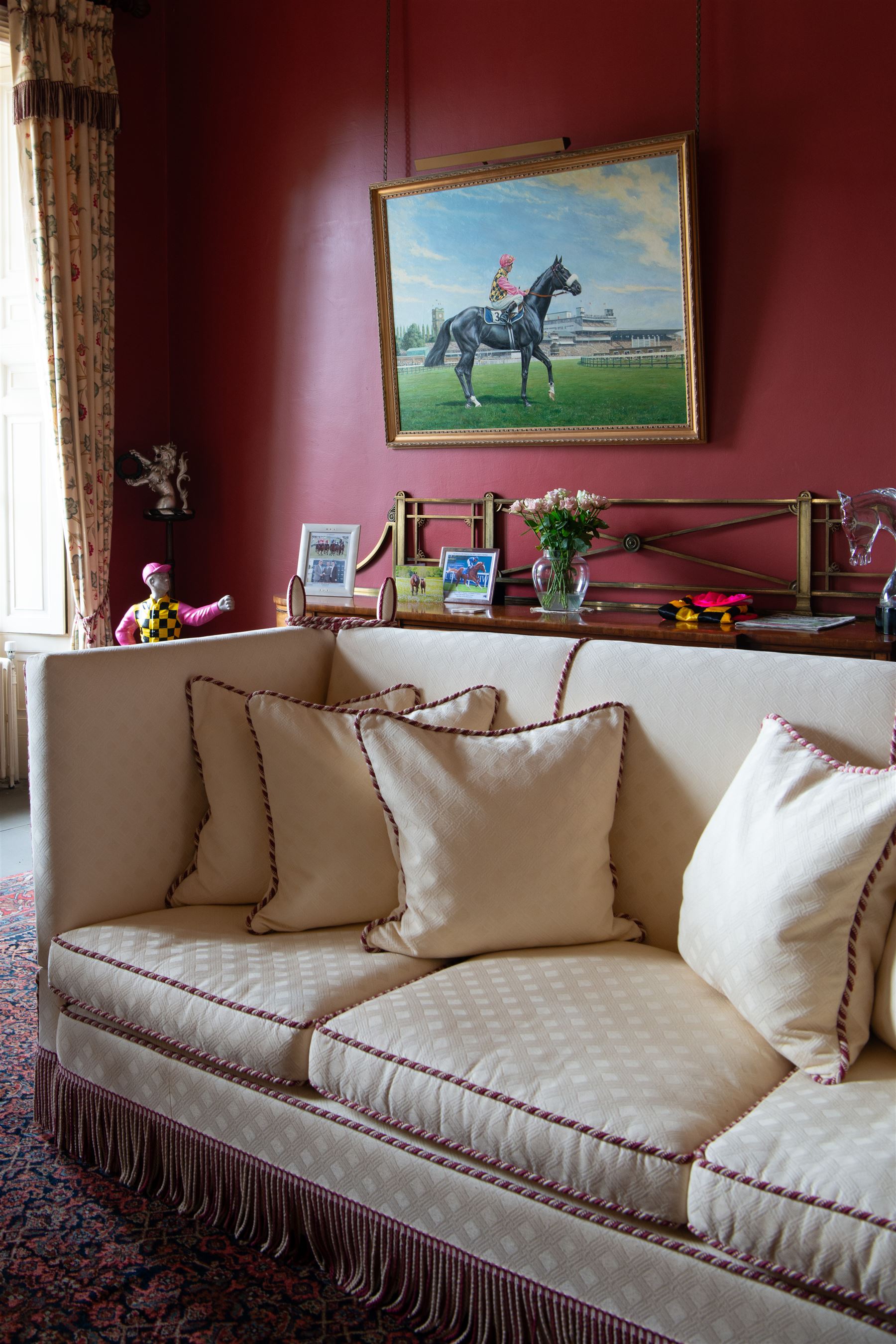 Grande Knole four-seat sofa, upholstered in geometric lozenge pattern cream fabric with burgundy and cream twist piping and fringe, on castors