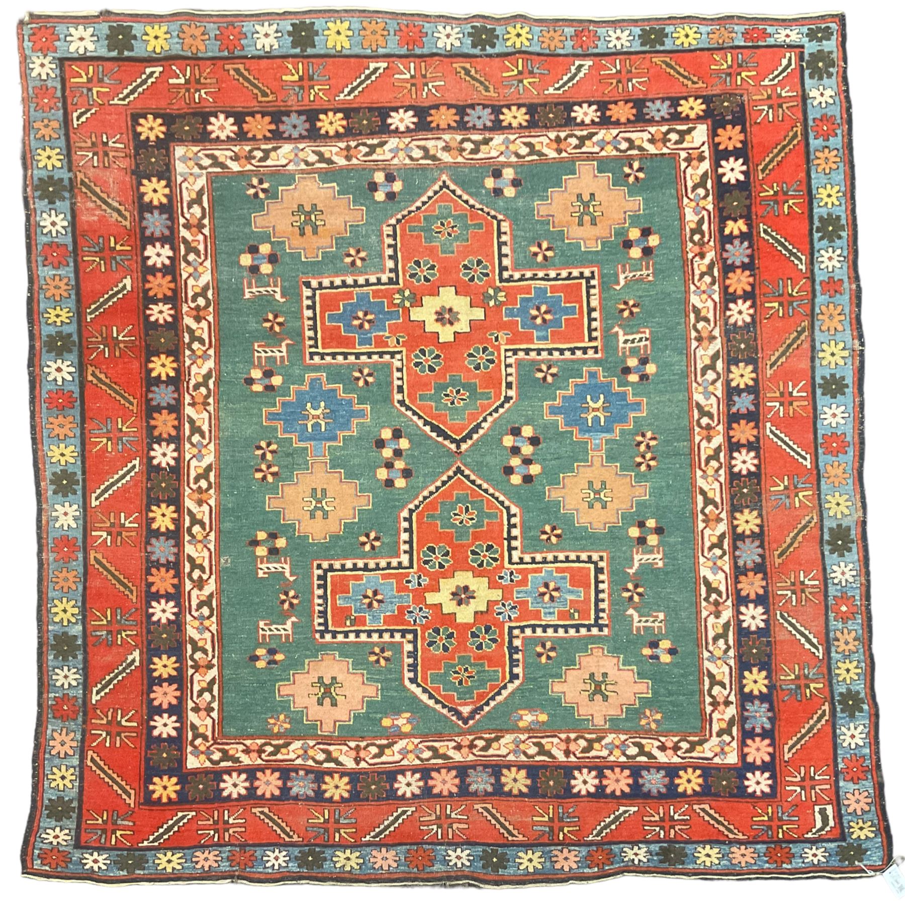 Caucasian turquoise ground rug, two medallions on a field decorated with stylised animal and geometric motifs, the guarded border decorated with further geometric motifs