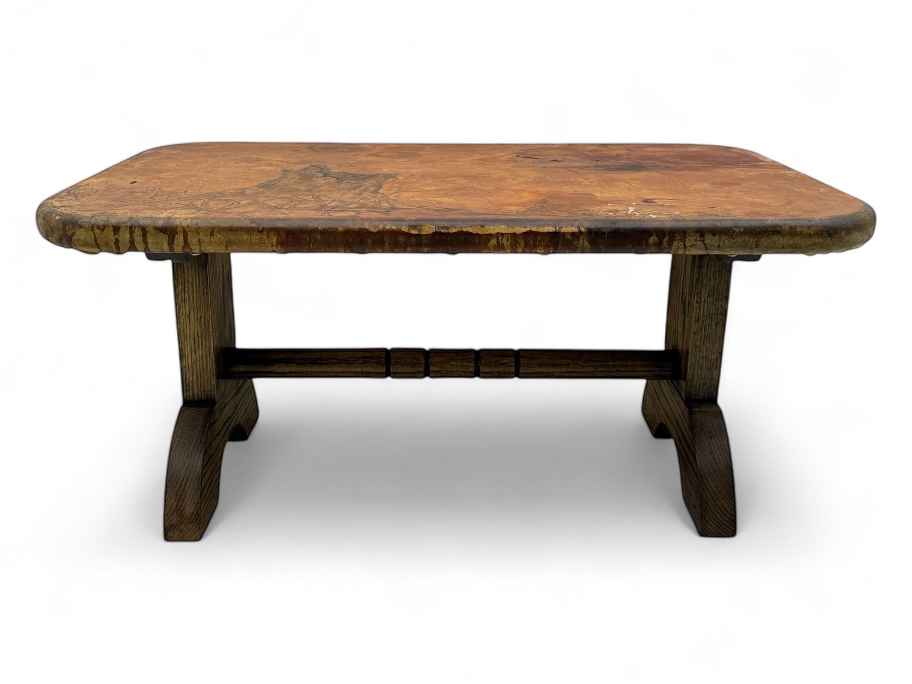 Rectangular oak coffee table, rectangular top with tan leather cover decorated with naturalistic scene, on rectangular end supports and curved feet united by turned stretcher 