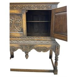 Jacobean Revival carved oak cupboard, moulded rectangular top over S-scroll carved frieze and two doors, the panelled doors carved with stylised plant motifs, on stand decorated with lunettes and shaped apron with hanging turned pendant, on turned supports united by stretchers 