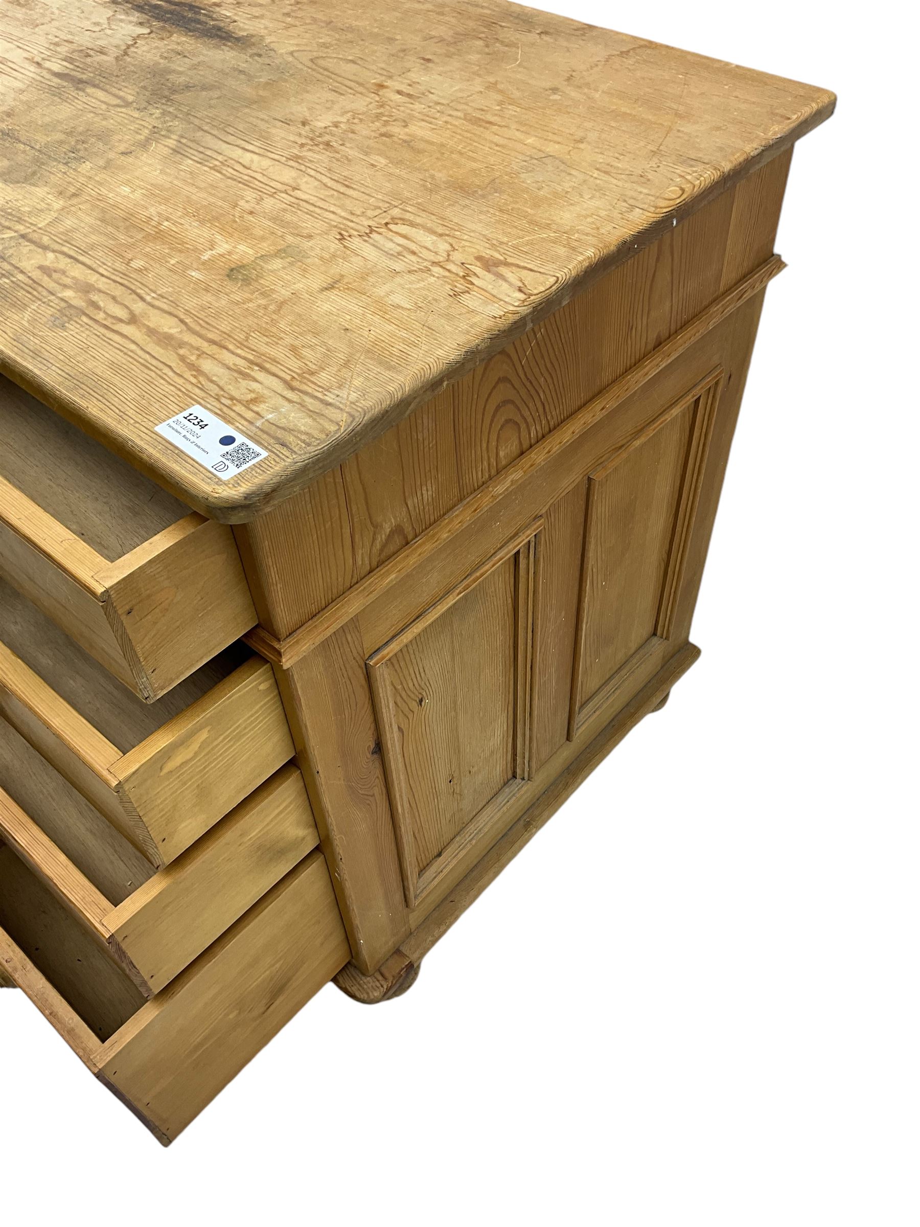 Waxed pine twin pedestal desk, rectangular top over nine drawers, on compressed bun feet 