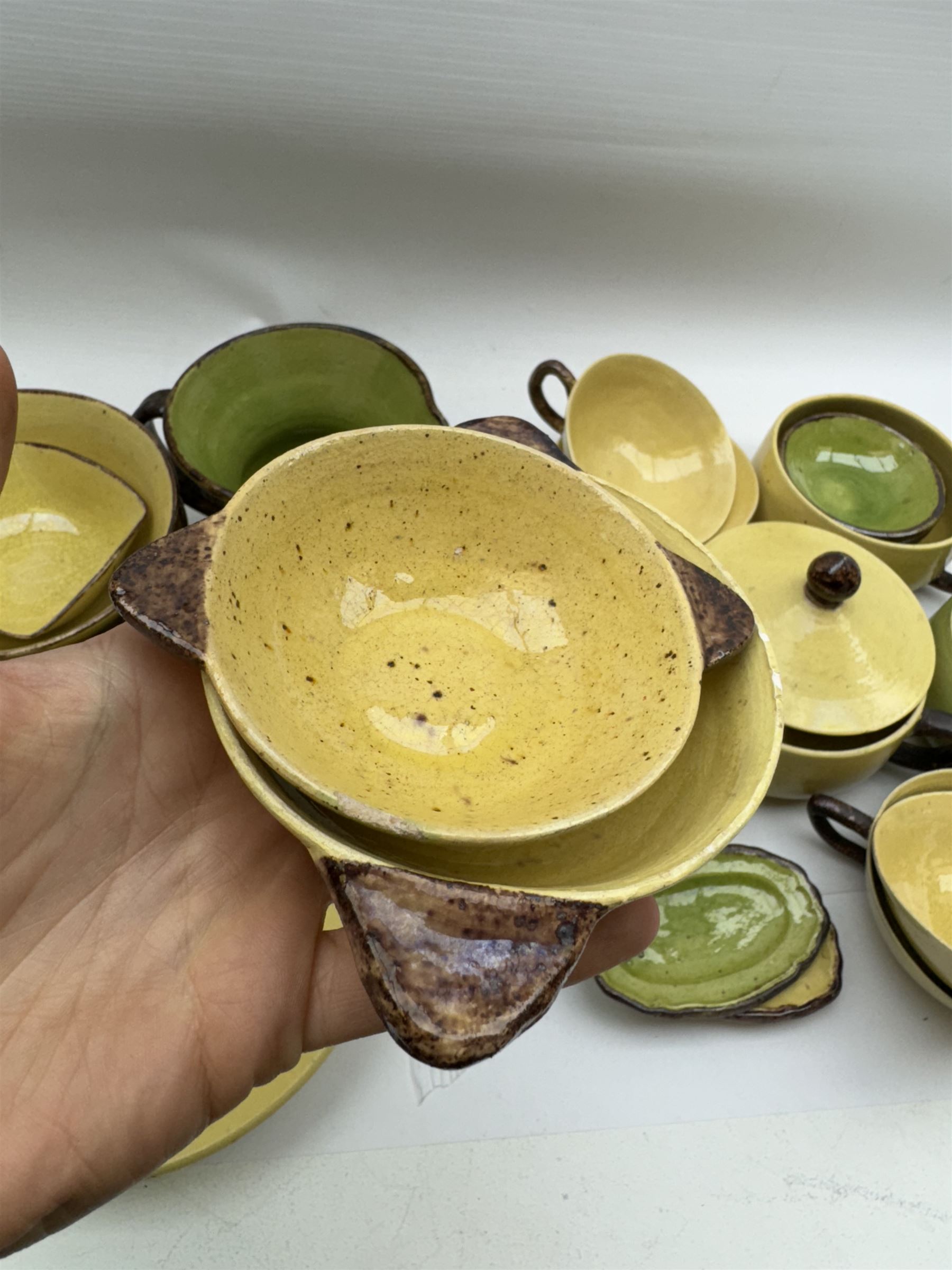 French green and yellow glazed tea and dinner wares by Etienne Noel, including milk jugs, teacups, side plates, bowls etc (43)