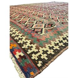 Northeast Persian Sumak Kilim red ground rug, the field decorated with rows of multicoloured diamond motifs featuring  geometric patterns, the border composed of alternating black and white stepped designs, enclosed by a narrow band with multicoloured geometric shapes