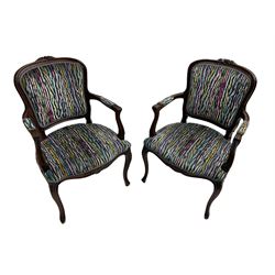 Pair of French design open armchairs, the moulded frame carved with flower heads, upholstered seat, back and arms, on cabriole supports