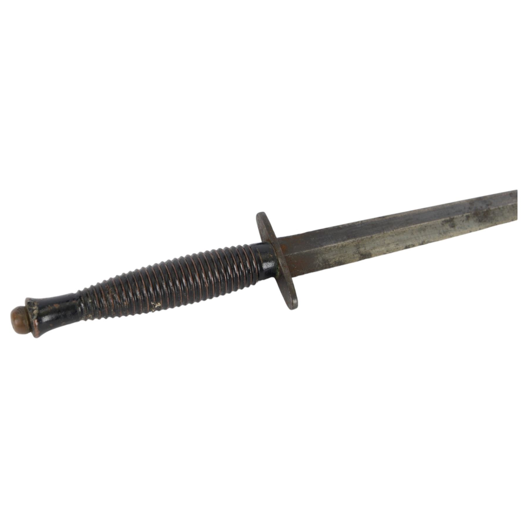 British commando knife, with ribbed ebonised steel hilt with a blued stiletto blade marked, with leather scabbard, blade 18cm