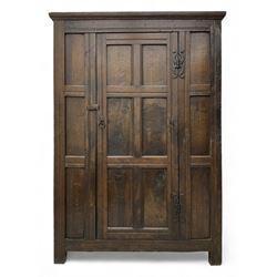 17th century and later oak hall cupboard, panelled front and sides with moulded frame, enclosed by single door with wrought metal hinges and handle, the interior fitted with hooks, on stile supports 