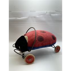 Steiff child's ride on ladybird, circa 1950s, the mohair body with red and black spotted seat, black and white face and blue underbelly, upon a metal frame with rubber and metal wheels, H30cm, W52cm