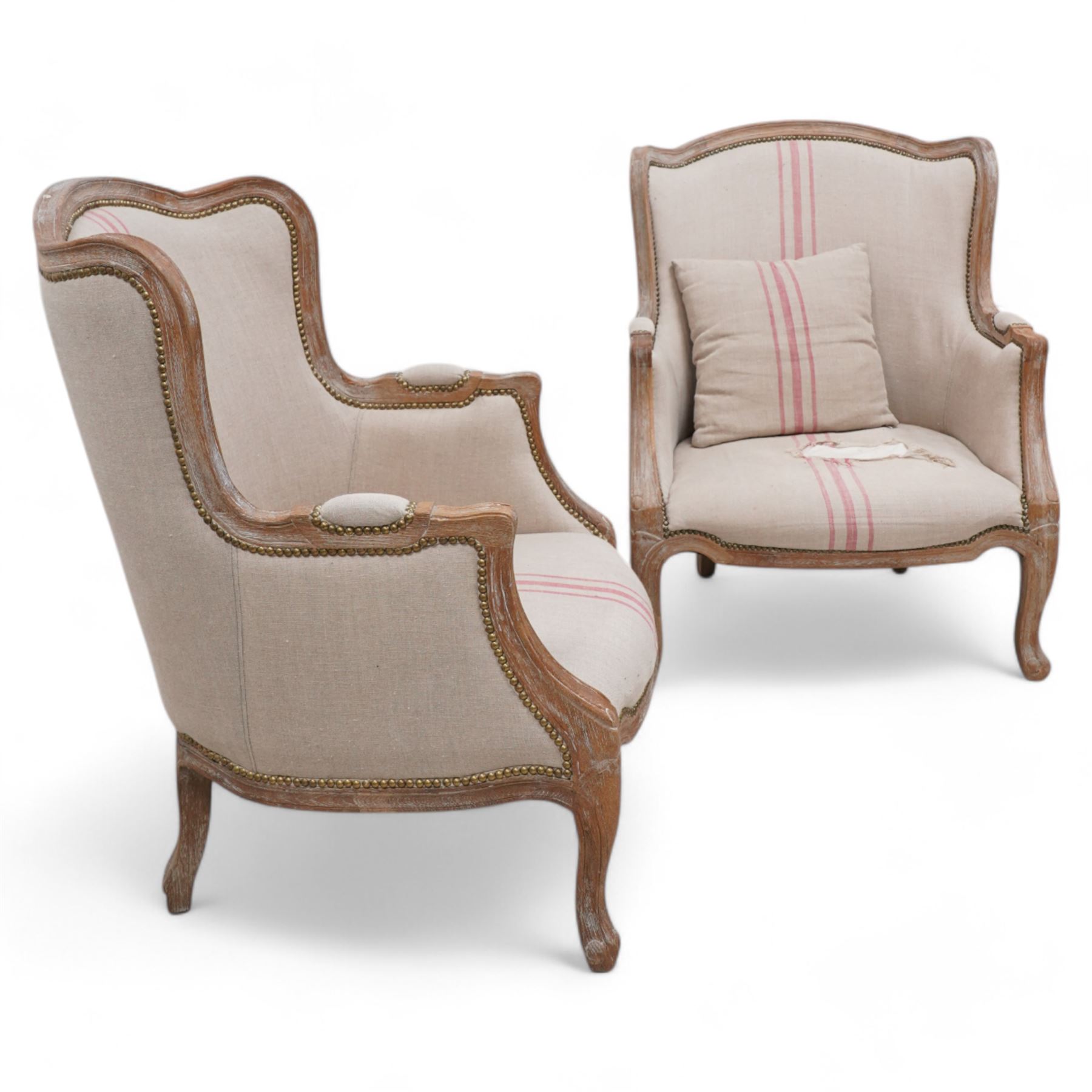 Pair of large hardwood-framed French design armchairs, moulded and shaped frames terminating to cabriole feet, upholstered in pale fabric with pink stripes 