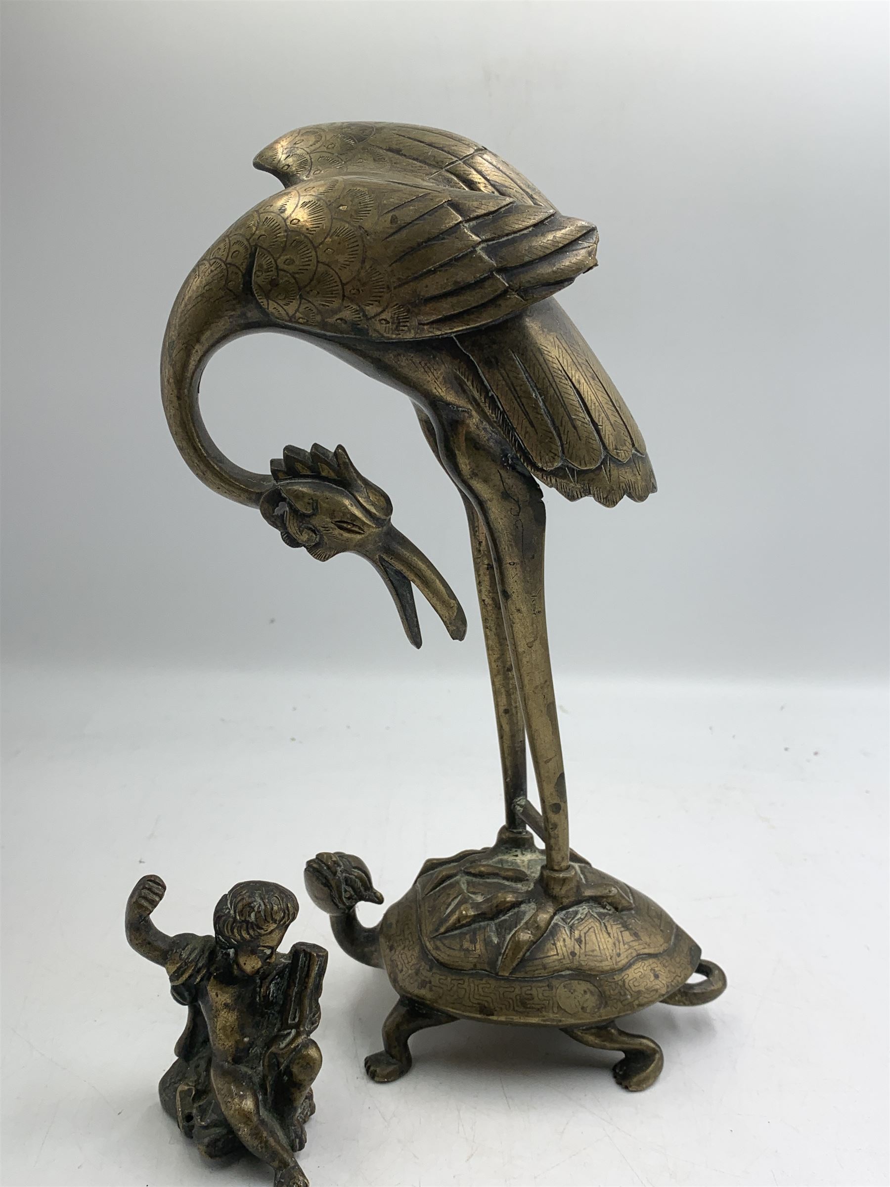 Early 20th century Japanese bronze figure or Okimono, modelled as a crane standing atop a turtle shell, possibly a candle holder, H25cm together with a small bronze figure modelled as a seated Cherub, H7cm (2)