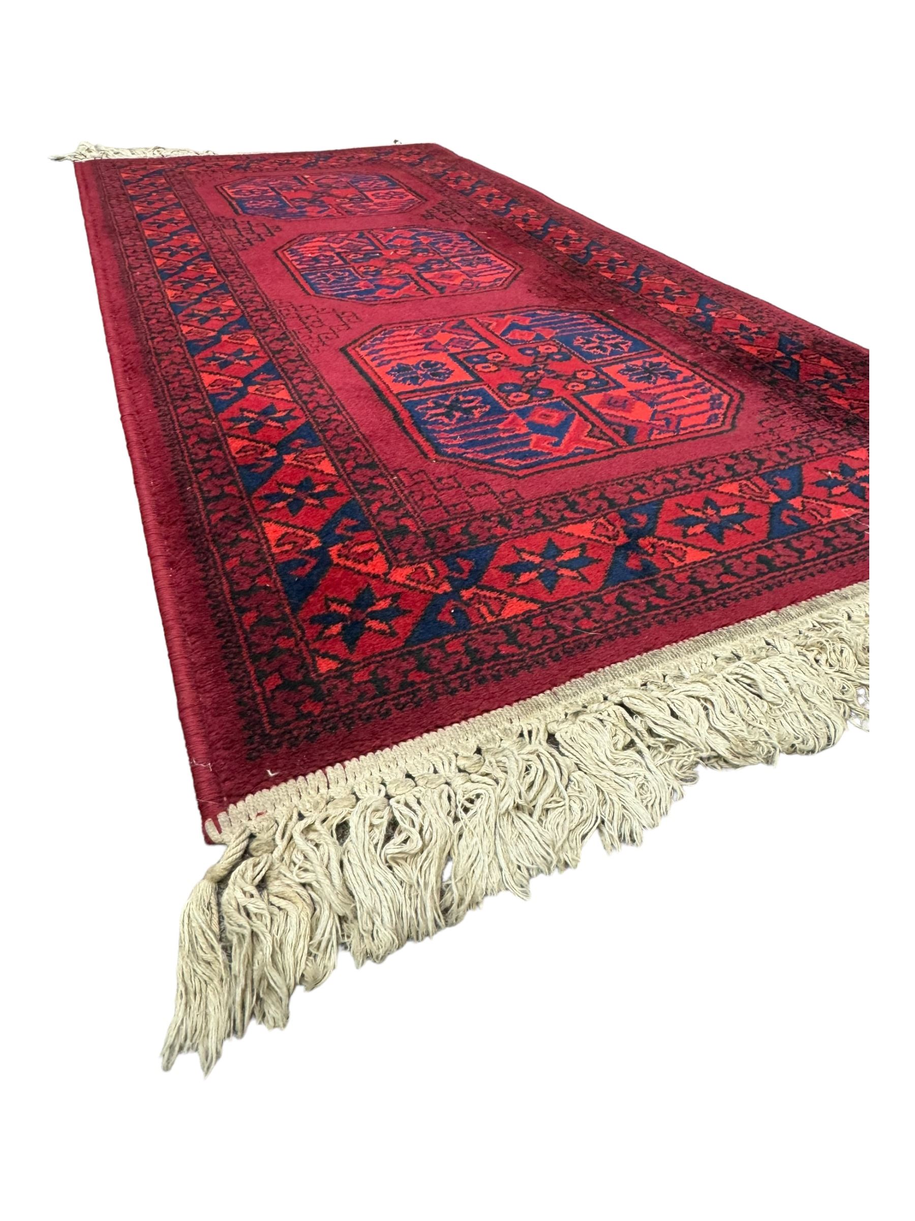 Persian Qashqai crimson ground rug, the field with central indigo and yellow medallion with geometric motifs, flanked by smaller medallions, border with repeating patterns (112cm x 200cm); Turkish Kazak light blue ground rug (109cm x 193cm); red ground runner with three octagonal medallions (69cm x 138cm)