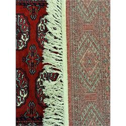 Persian Bokhara crimson ground runner rug, the field with a series of repeating ivory octagonal medallions, main border with repeating flower head pattern and diamonds within multiple guard stripes