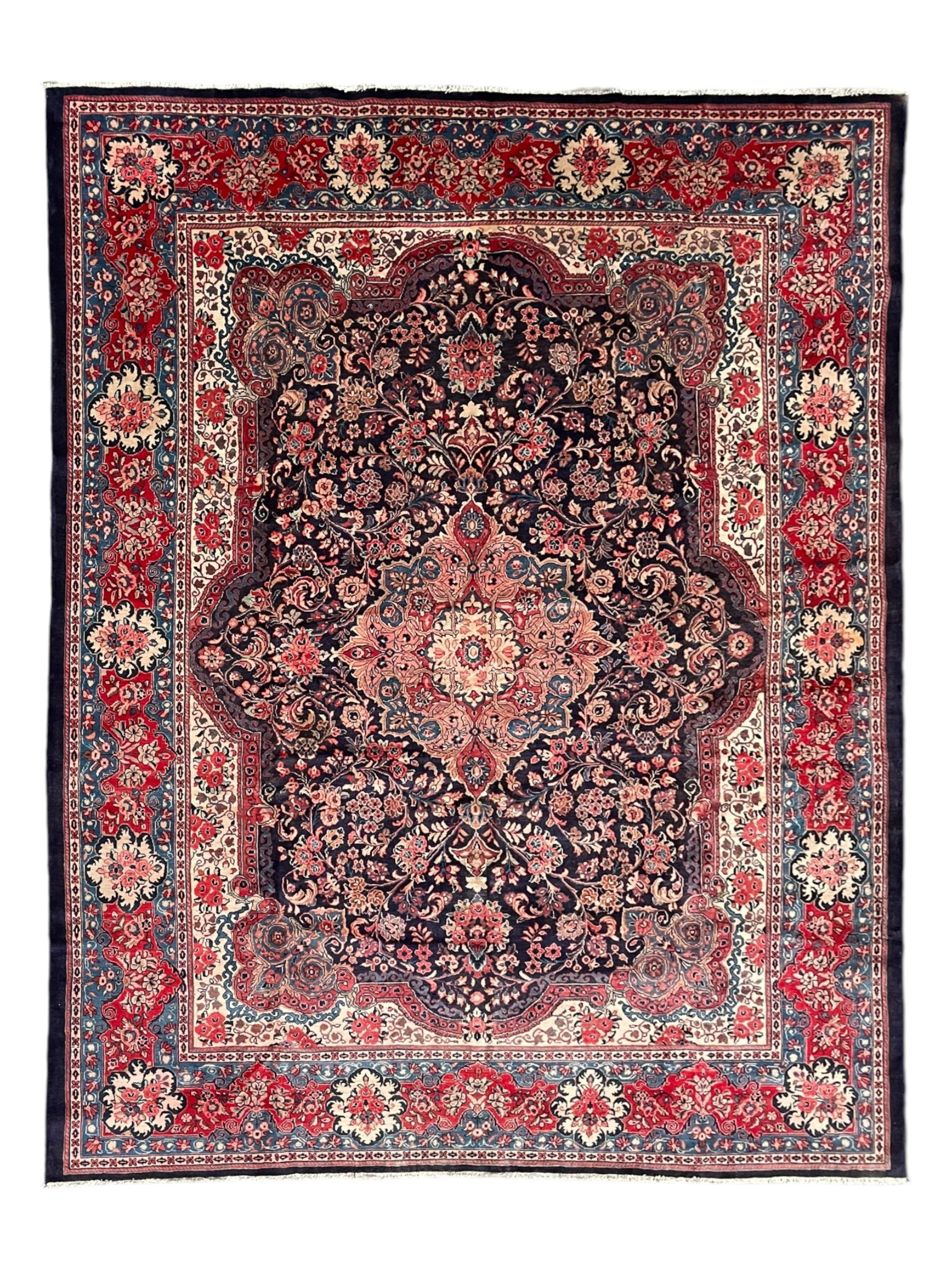 Persian Mahal indigo ground carpet, floral medallion on a field of swirling leafy branches and flower heads, shaped ivory field band decorated with flower head bouquets and trailing branches, the border decorated with floral motifs, within guard stripes