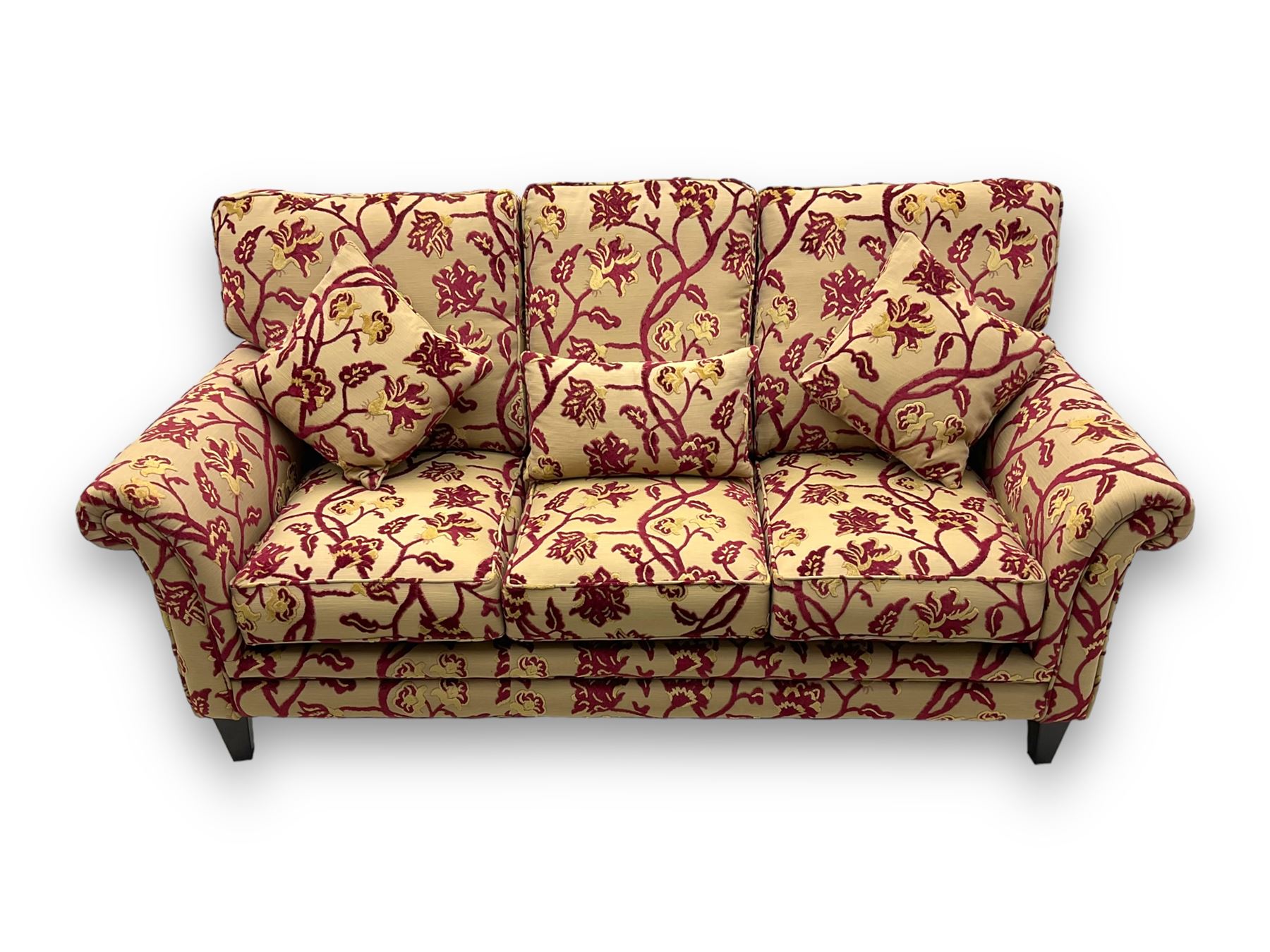 Contemporary upholstered three-seat sofa, scroll arms and loose cushions, embossed beige ground fabric with red and gold floral motifs, on tapered wooden supports