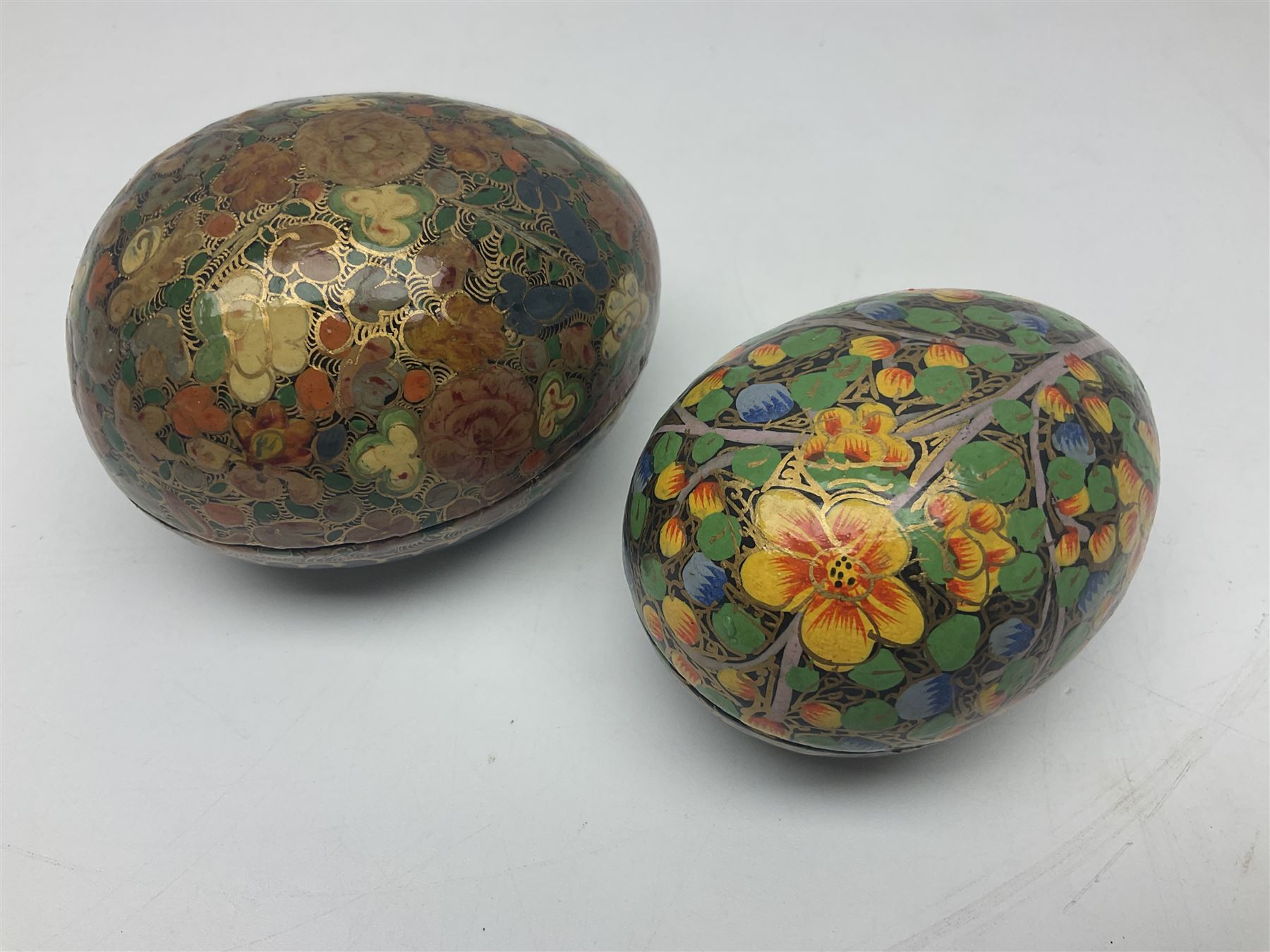 Seven lacquered boxes, of ovoid form, with floral decoration, largest H7cm, L10cm