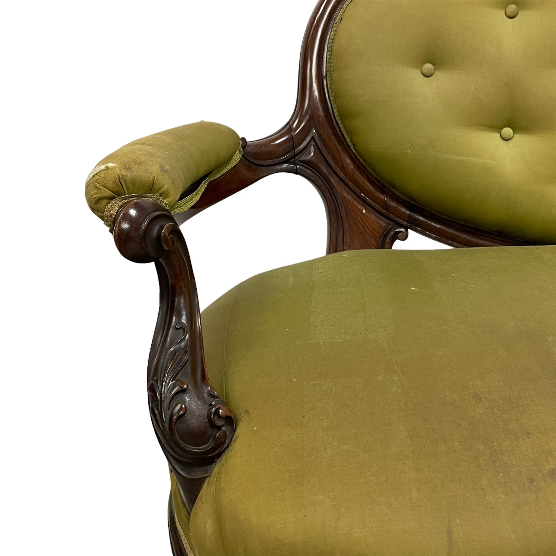 Victorian carved walnut framed two seat settee, cresting rail carved and moulded with a posy of roses and trailing foliate, over an oval back with scrolled arm terminals, serpentine fronted seat over cabriole supports with bell-flower carved knees, buttoned back and sprung seat upholstered in olive green fabric