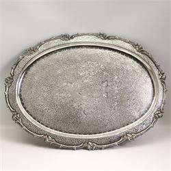 Continental silver-plated part dinner service comprising two graduated entree dishes & oval platters and salver, all having scroll cast borders and foliate engraved design, oval tray max L65cm 