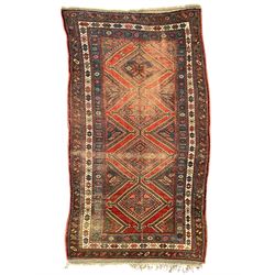 Kurdish crimson ground rug, the field decorated with four lozenge medallions, triple band ...