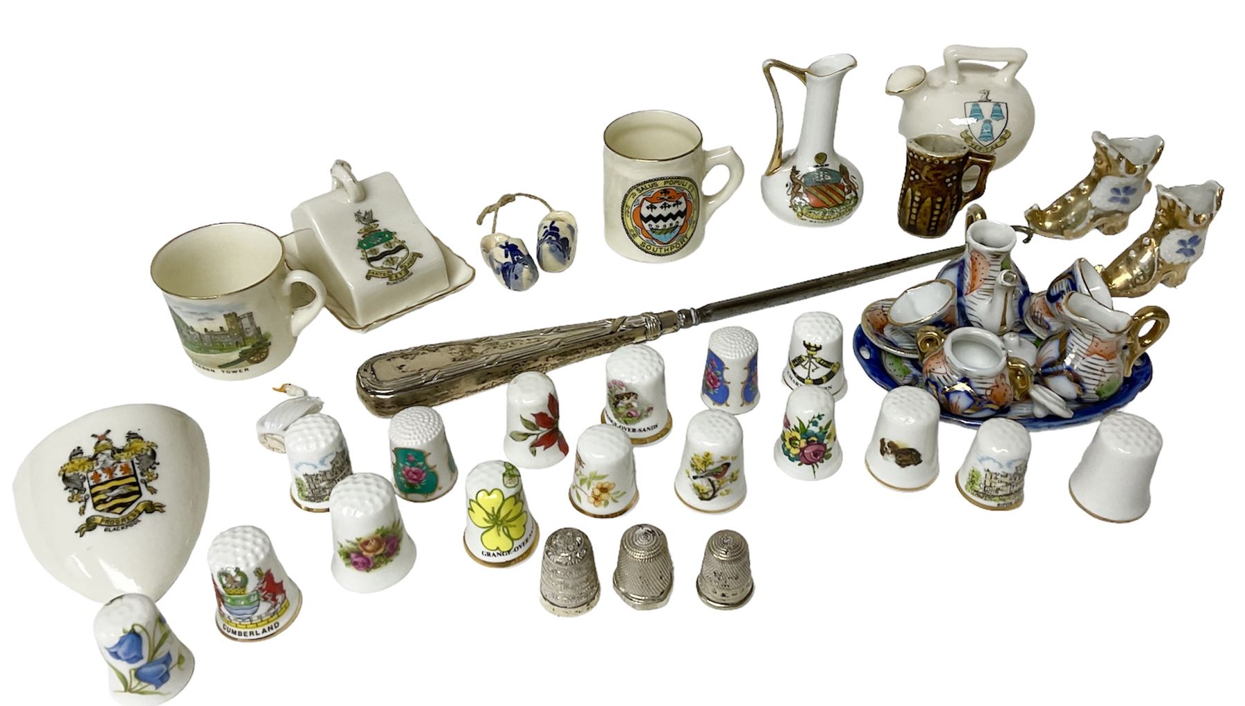 Three hallmarked silver thimbles, a hallmarked silver handled button hook, crested ware including items by W.Goss, miniature oriental style tea set and a collection of ceramic souvenir thimbles