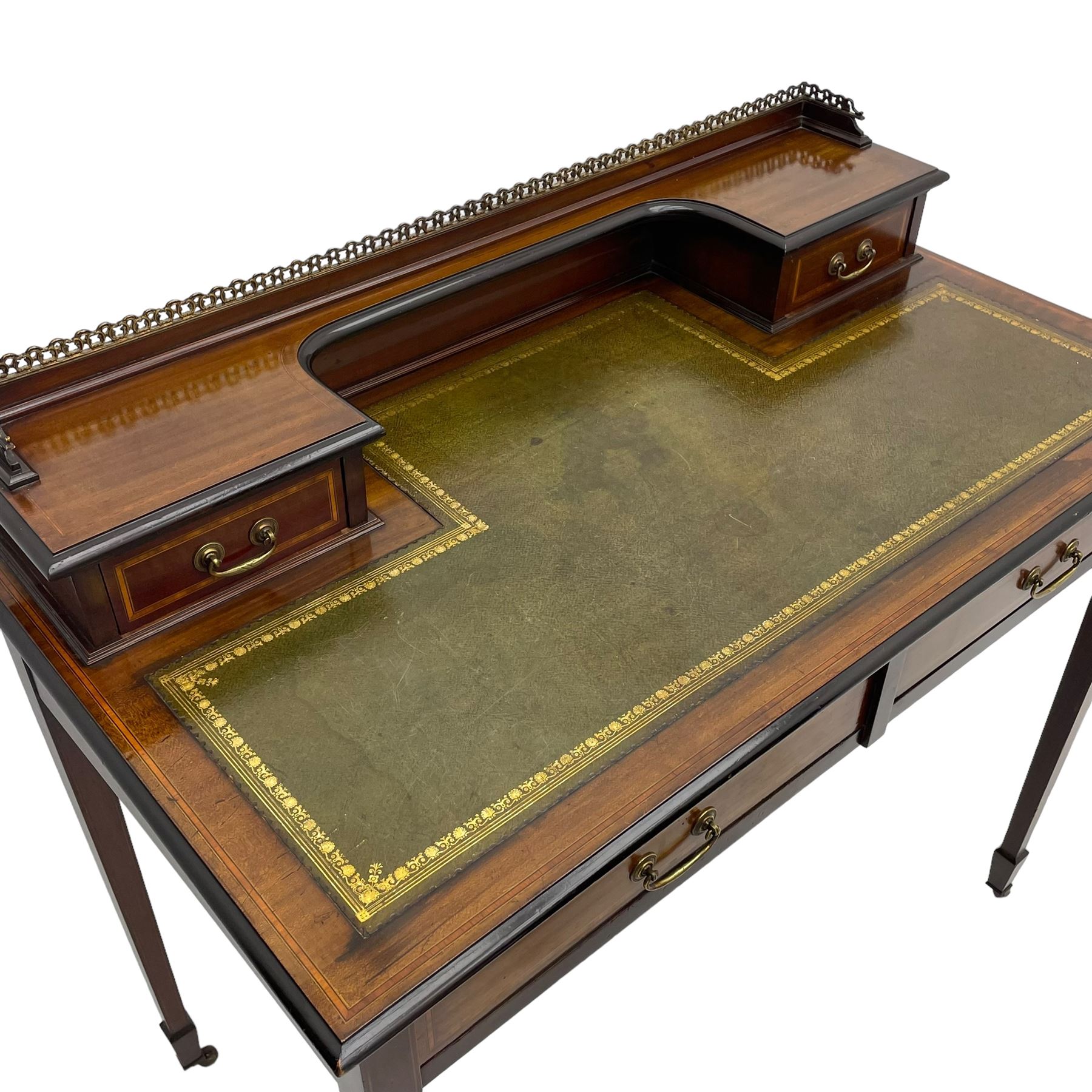 Edwardian inlaid mahogany writing desk, raised back with gilt metal gallery over two small drawers with satinwood banding, the rectangular moulded top with green leather inset writing surface, fitted with two drawers, on square tapering supports with spade feet, brass and ceramic castors 