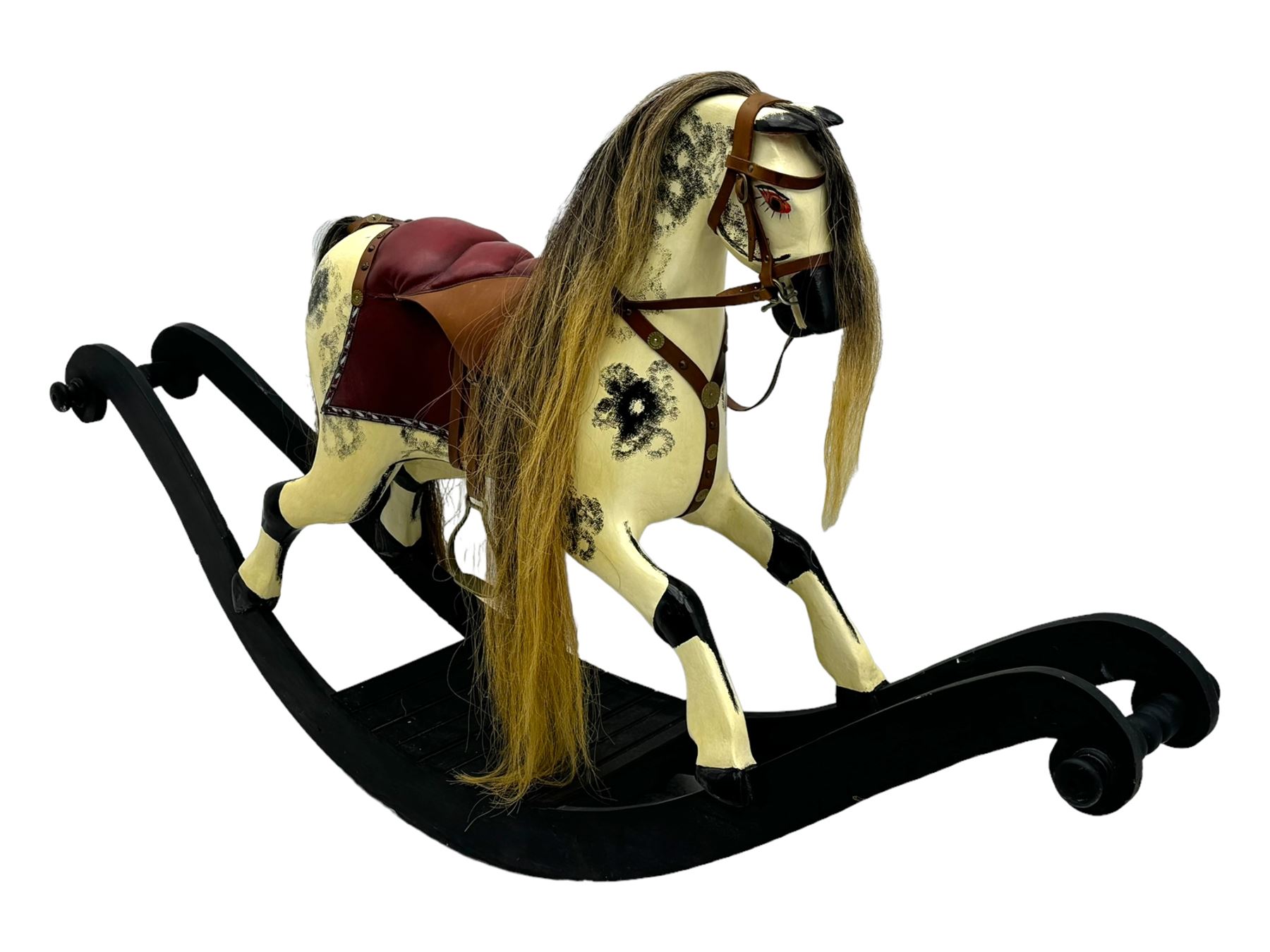 Mid-to-late 20th century carved wooden rocking horse, in dapple grey finish with leather saddle and bridle, mounted on a black painted rocking frame with shaped ends