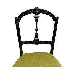 Set of four late Victorian ebonised dining chairs, decorated with carved and gilt foliate decoration, upholstered seats, on turned and fluted front supports 