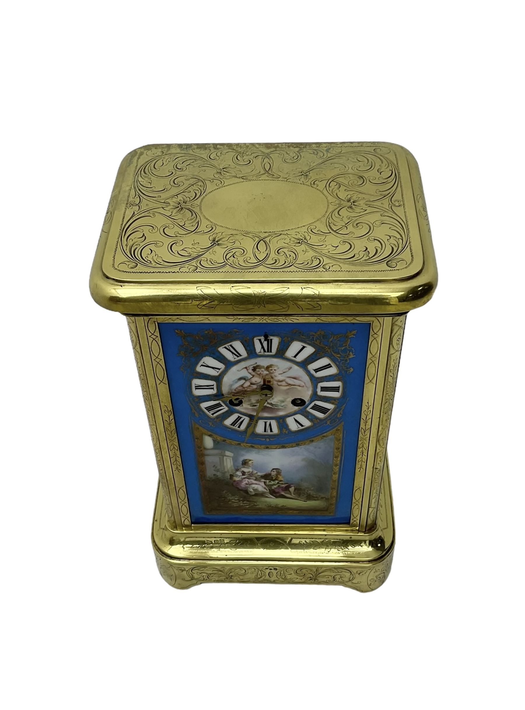 French - late 19th century 8-day mantle clock in an engraved brass corniche case with three rectangular porcelain panels decorated in the romantic Sevres style, dial with brass hands, cartouche Roman numerals and a depiction of cupid to the dial centre, rack striking movement sounding the hours and half hours on a bell. With pendulum.