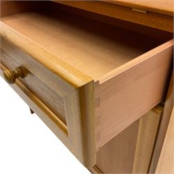 Mid 20th century teak bureau, sloped fall-front opening to reveal fitted interior with compartments, over panelled full width drawer and two cupboard doors, on recessed plinth base