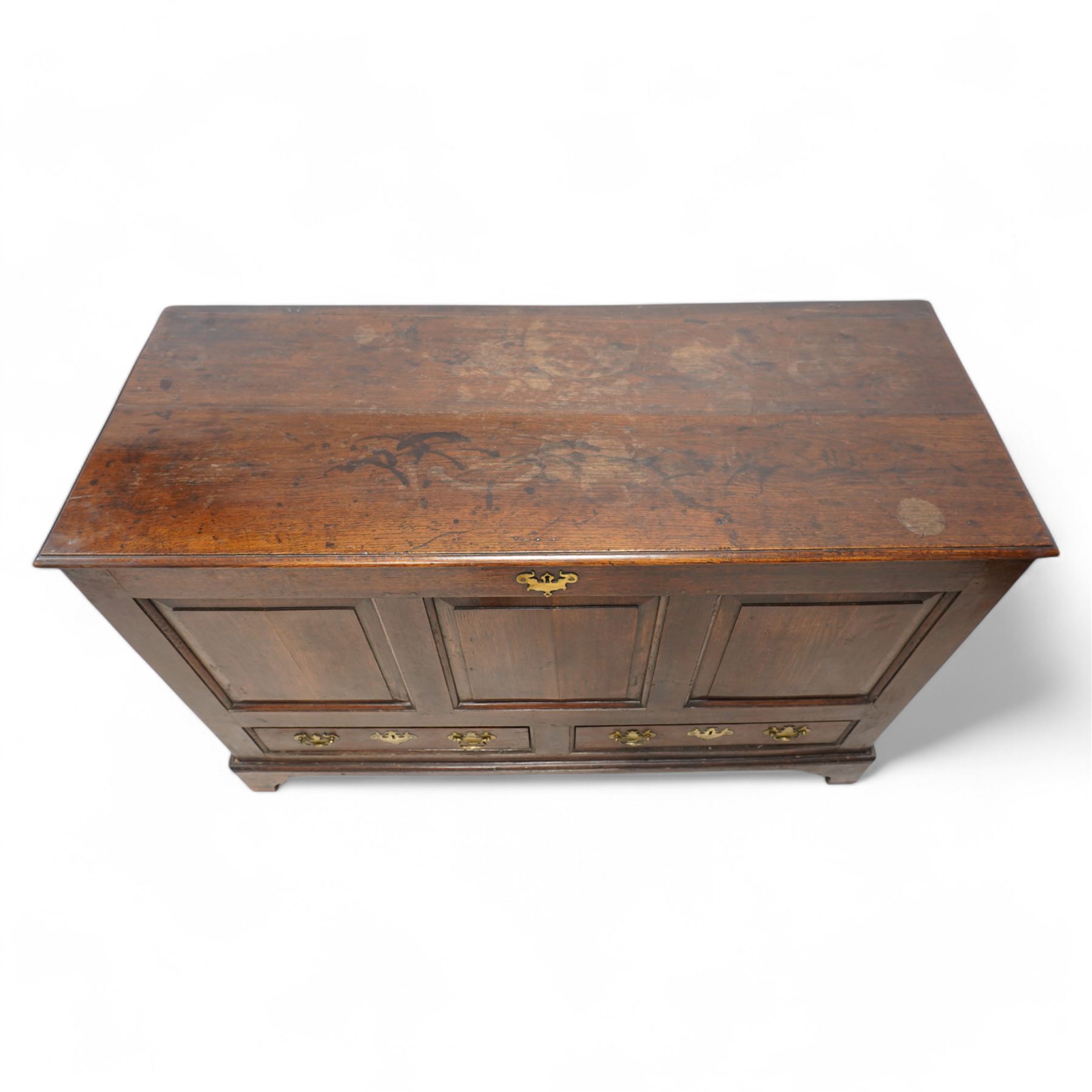 18th century oak mule chest, rectangular hinged top enclosing main compartment, over a triple fielded panelled front, two drawers fitted to base, lower moulded edge on shaped bracket feet